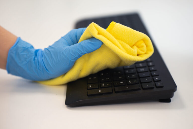 Cleaning the office with a microfiber cloth and gloves