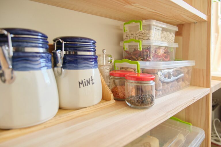 Wooden shelves with food and kitchen utensils in the pantry